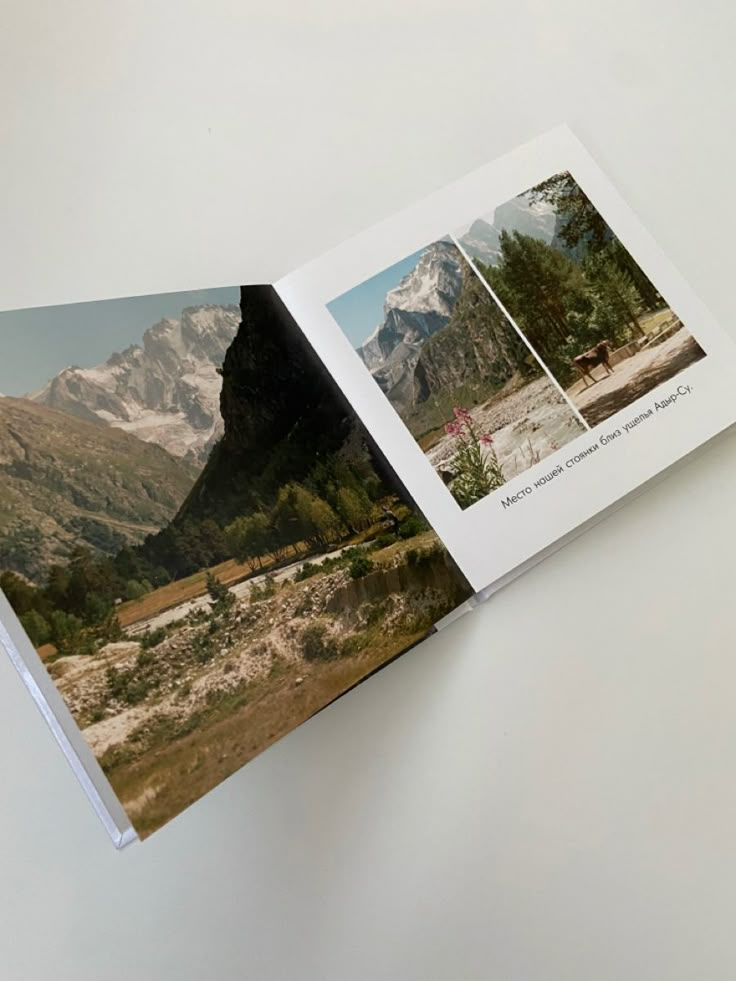 an open photo book with mountains in the background