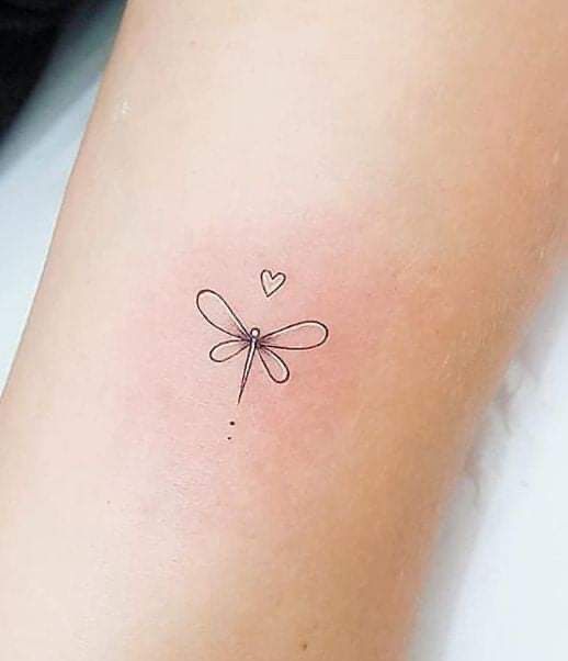 a small dragonfly tattoo on the left side of the arm, with a heart in the middle