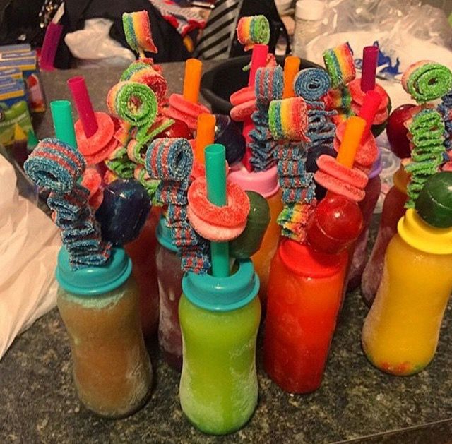 there are many different colored drinks in the bottles with straws sticking out of them