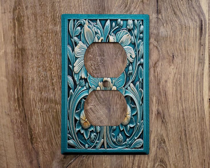 a decorative light switch cover on a wooden wall