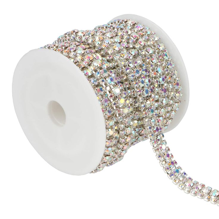 a spool of white and silver colored crystal beaded ribbon on a white background