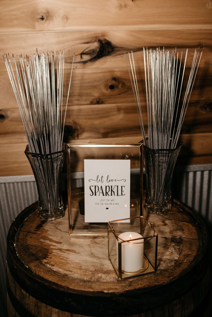 a candle sits on top of a wooden table next to a sign that says let love sparkle