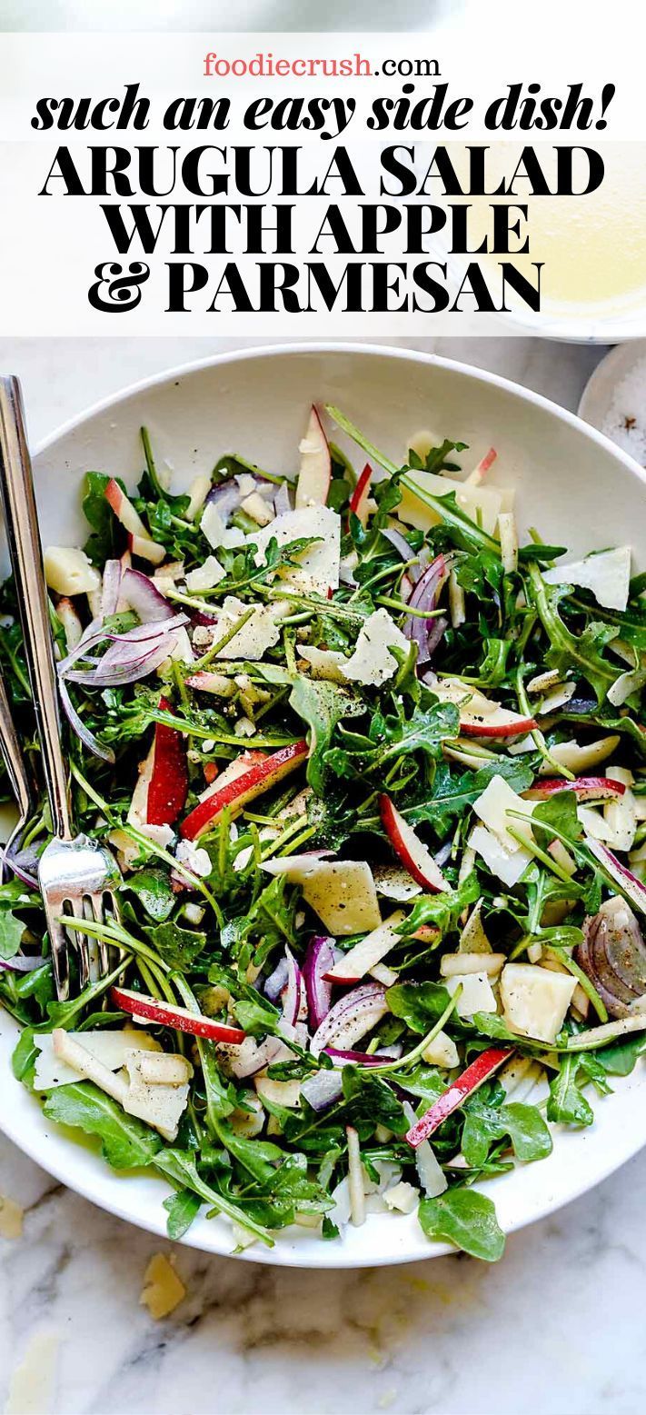 a salad with spinach, radishes and parmesan in a white bowl