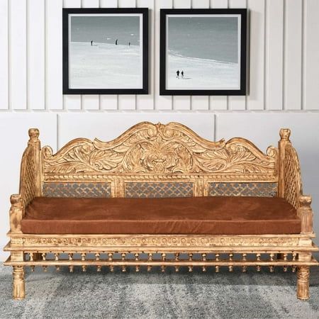 a wooden bench sitting in front of two framed pictures on the wall next to a carpeted floor