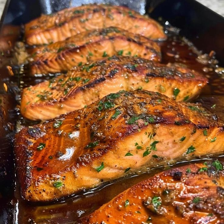 some salmon fillets are cooking in a pan