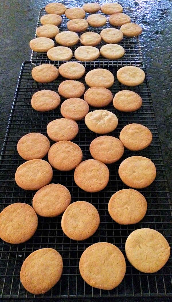 several cooling racks filled with cookies on top of a table