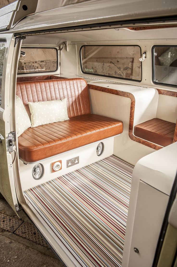 the inside of a vehicle with two seats and a rug on the floor next to it