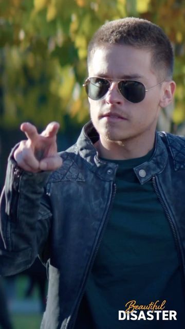 a young man wearing sunglasses making a hand gesture