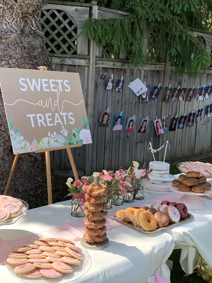 a table topped with lots of pastries next to a sign that says sweets and treats