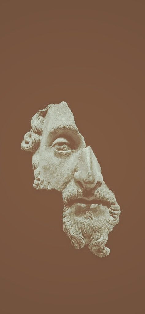 an old statue of a man's head on a brown background