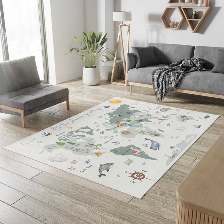 a living room with grey couches and a white area rug on the wooden floor