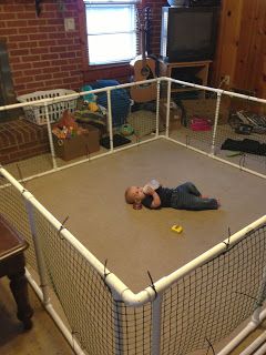 a man laying on the ground in front of a caged area with a television