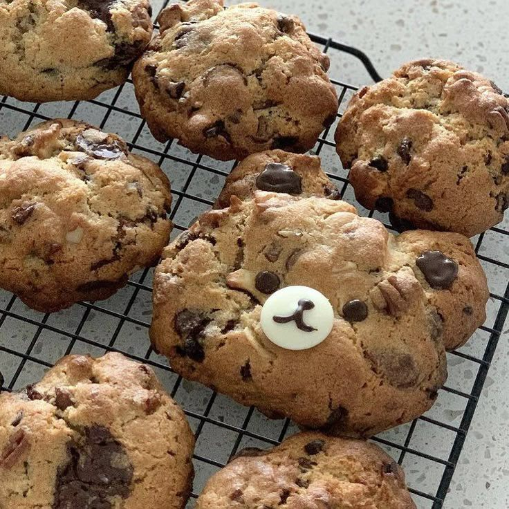 chocolate chip cookies with white frosting and a teddy bear nose on a cooling rack