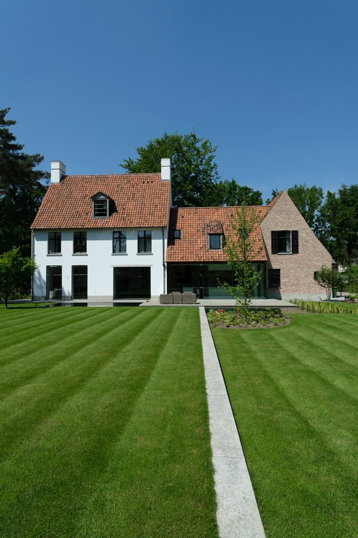 a white house with red tile roof and green grass