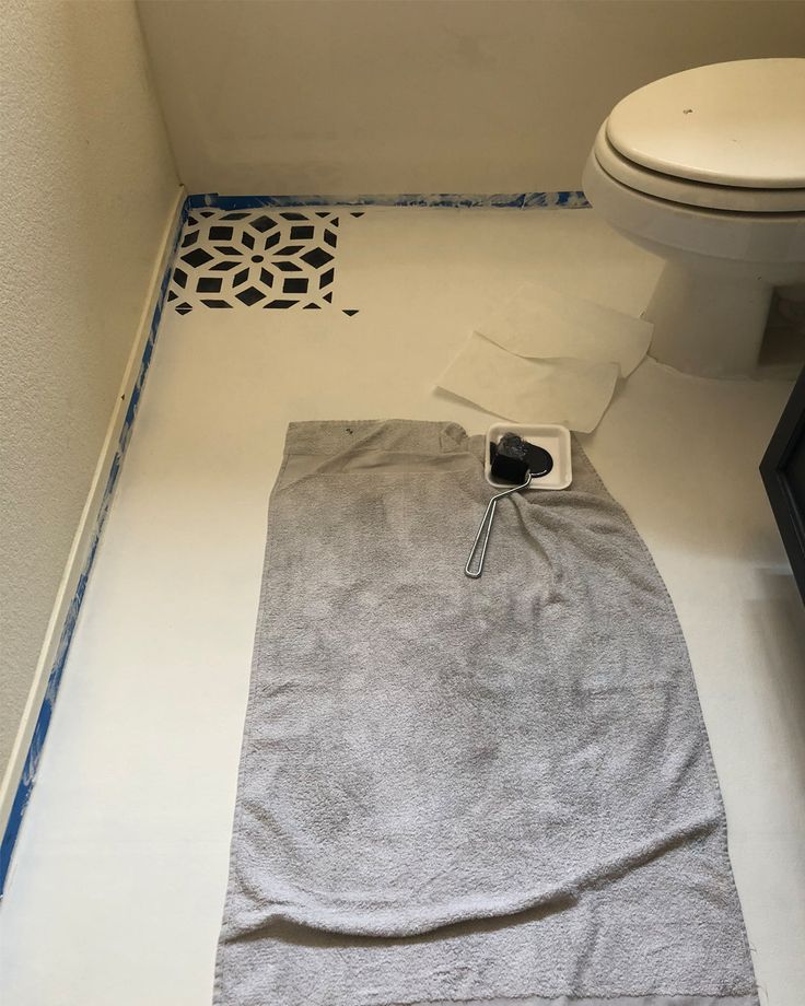 a white toilet sitting in a bathroom next to a gray towel