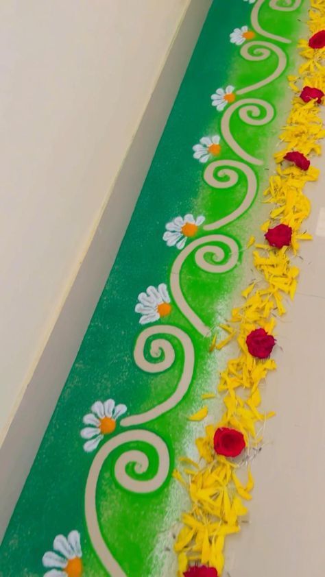 there is a green and yellow table with flowers on the top, along with white walls