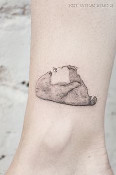 a small bear tattoo on the ankle