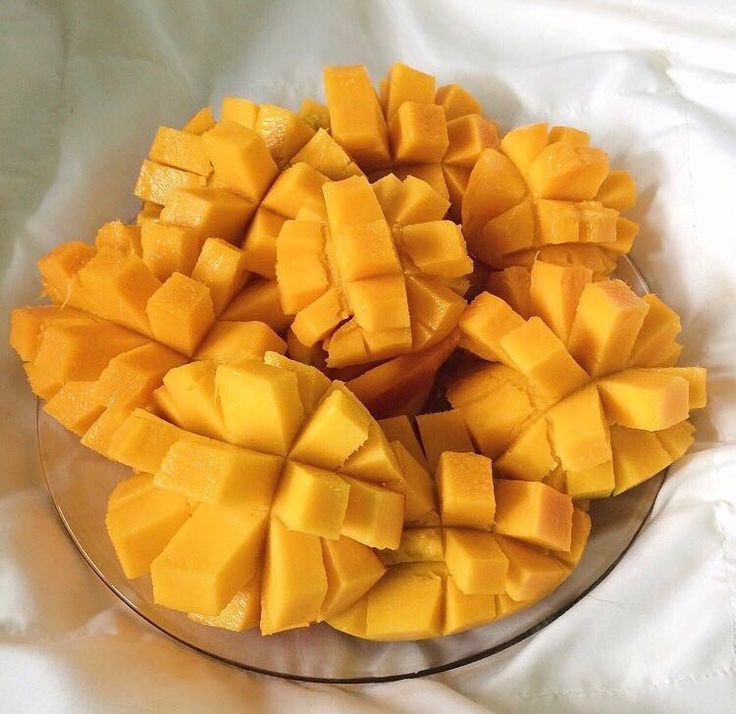 a glass bowl filled with cut up pieces of mango