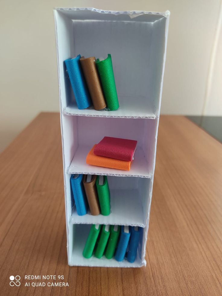 an open book shelf filled with colorful books on top of a wooden table next to a wall