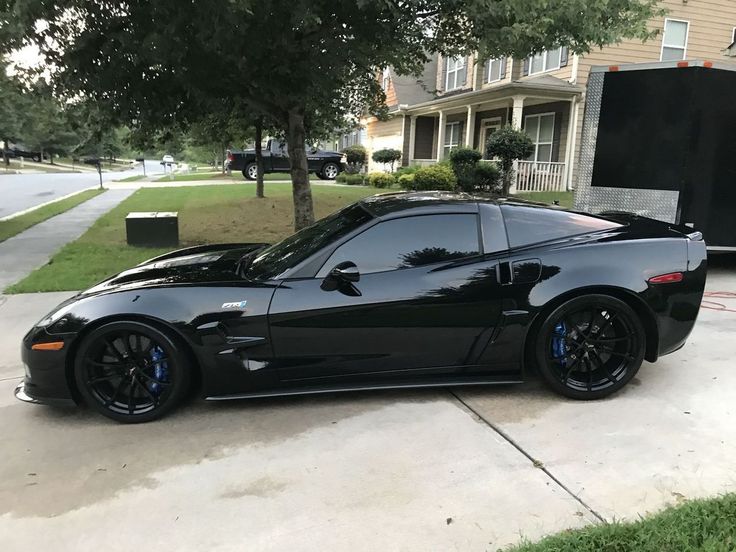 a black sports car parked in front of a house