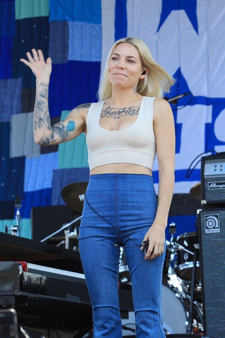 a woman standing on top of a stage with her hands in the air