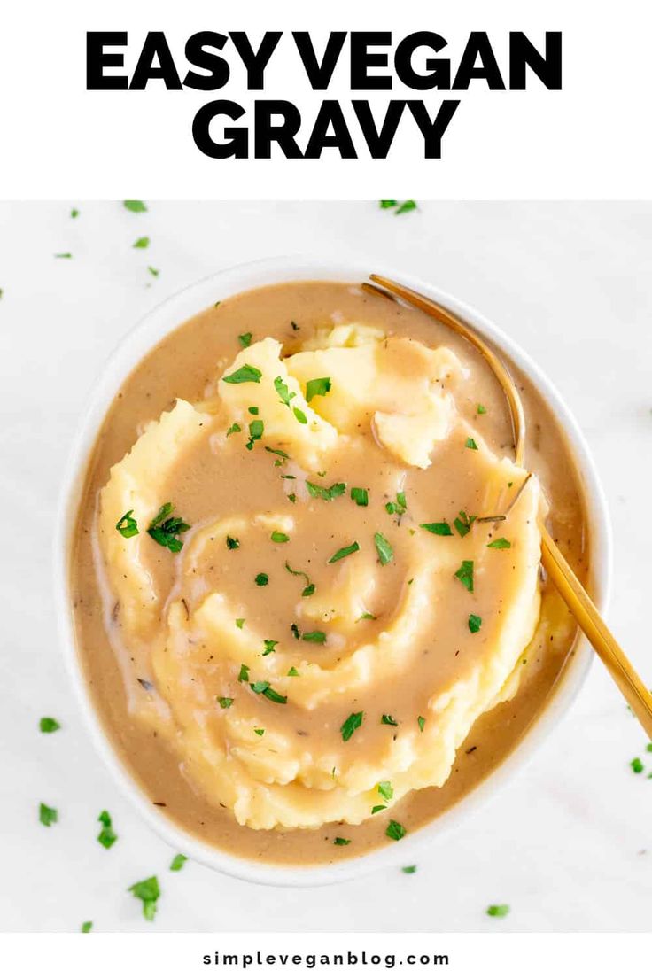 a bowl filled with mashed potatoes and gravy on top of a white table