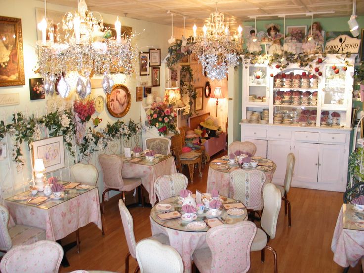 a dining room filled with lots of tables and chairs covered in white tablecloths