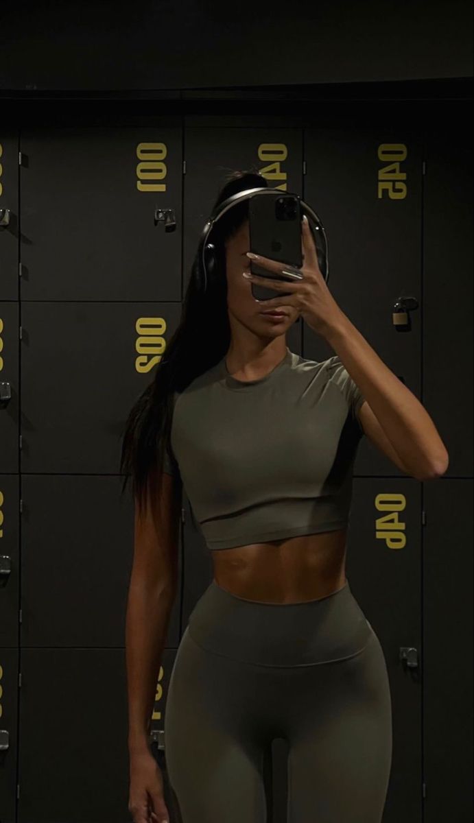 a woman is taking a selfie in front of lockers with headphones on