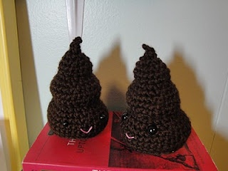 two brown crocheted cones sitting on top of a red box next to each other