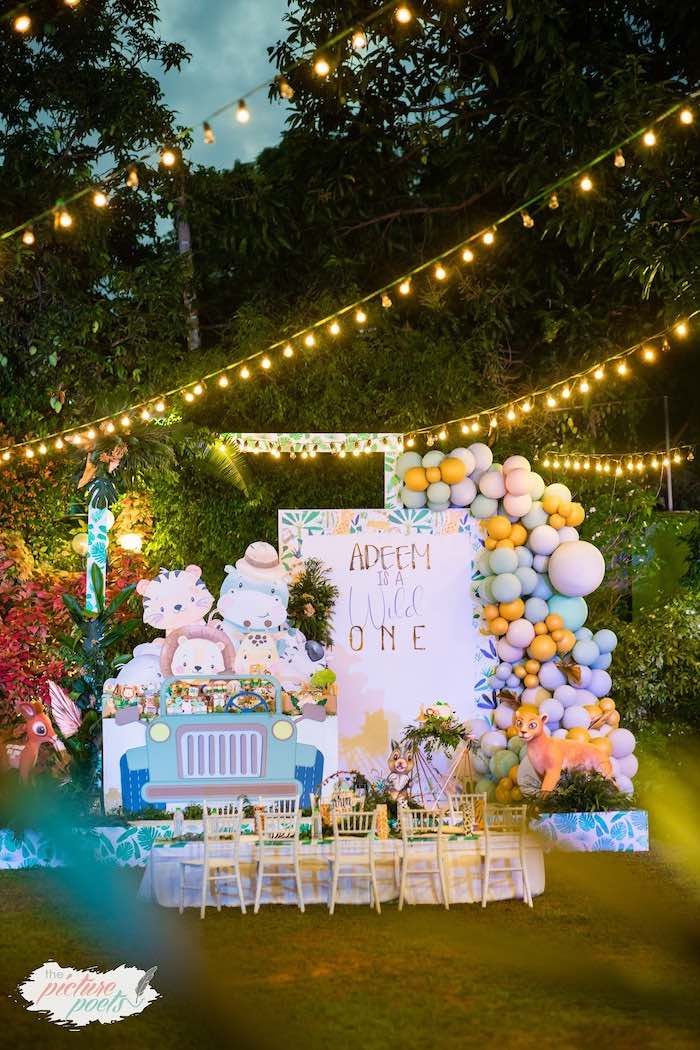 an outdoor party setup with balloons, lights and teddy bears on the back of a truck