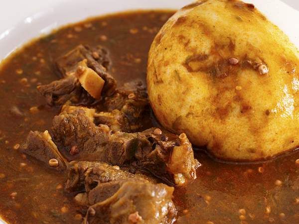 a white bowl filled with stew and meat