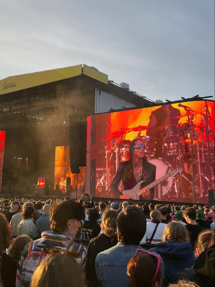 a large group of people sitting in front of a stage with an image on it