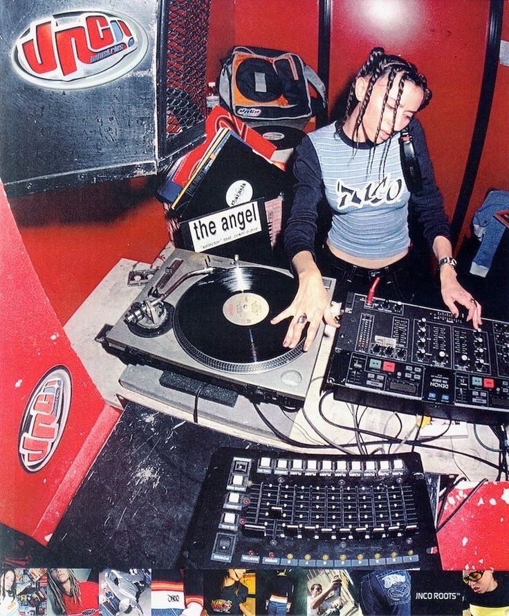 a woman with dreadlocks is playing music on a turntable and mixing equipment