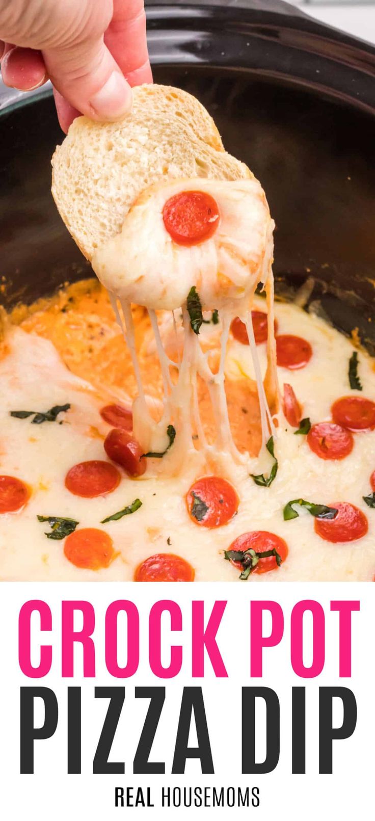 a hand holding a piece of bread over a pizza dip in a crock pot