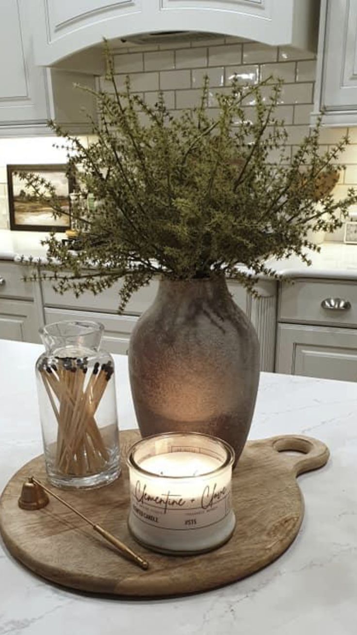 a candle sits on a cutting board in the middle of a kitchen