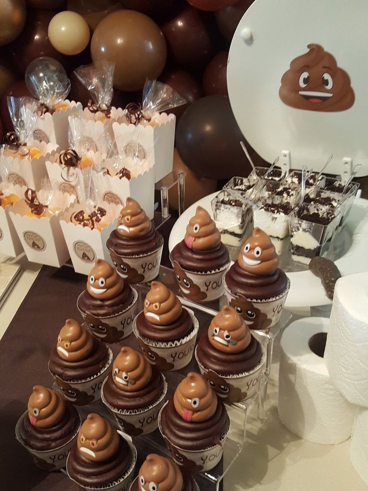 there are many cupcakes on the table with brown frosting and chocolate decorations