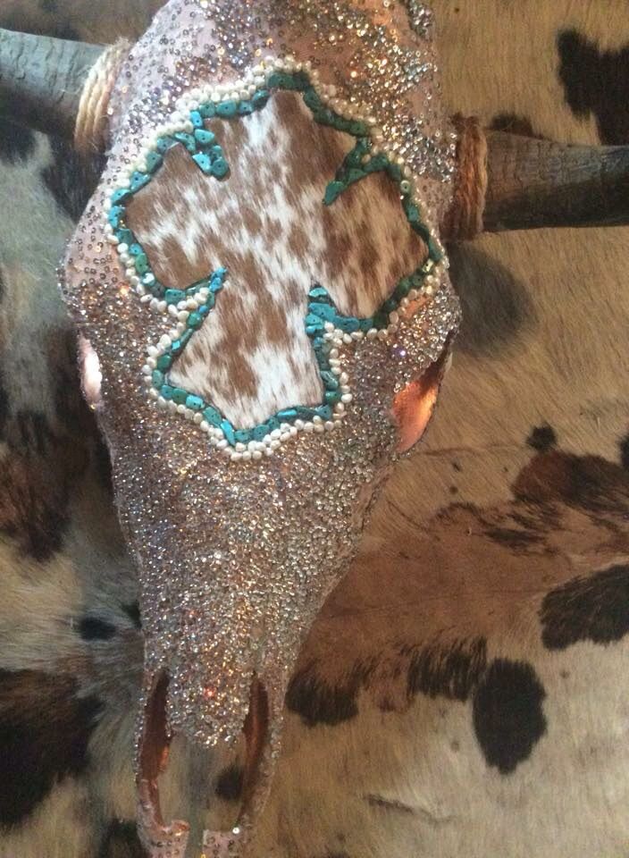 a cow's head is adorned with turquoise and white beaded decorations on it