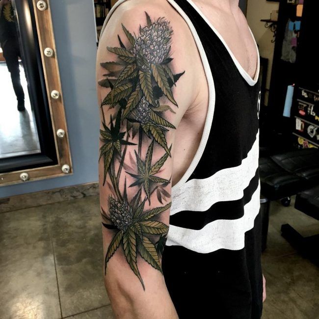 a man with a flower tattoo on his arm and shoulder is standing in front of a mirror