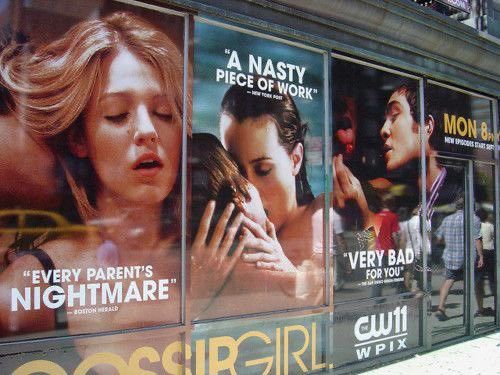 a movie poster on the side of a building in front of a window with advertisements