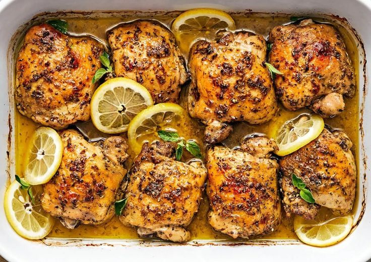 chicken with lemons and herbs in a white casserole