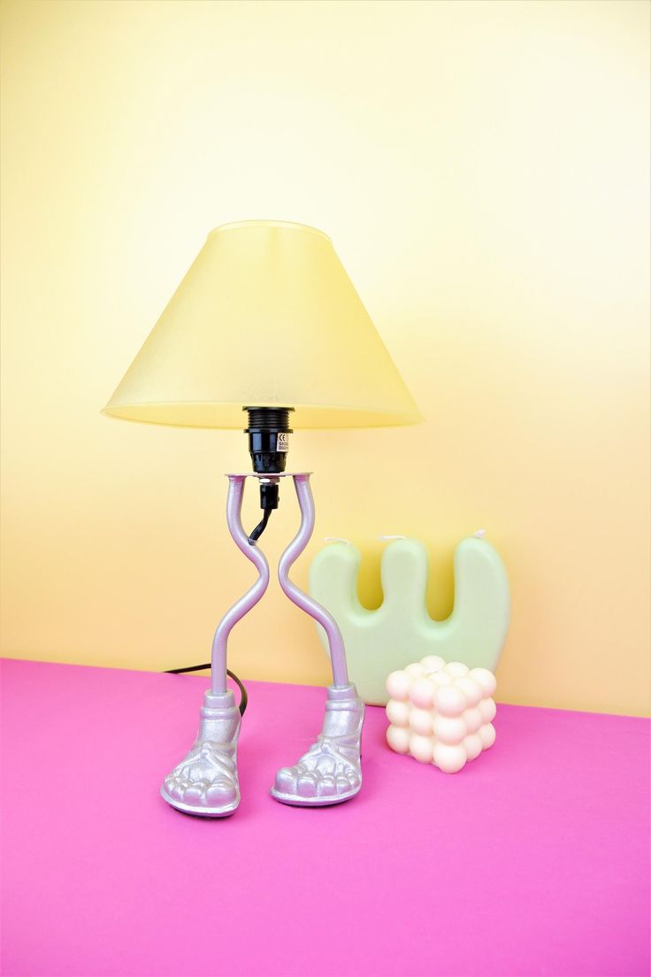 a lamp that is on top of a table next to a pair of tennis shoes