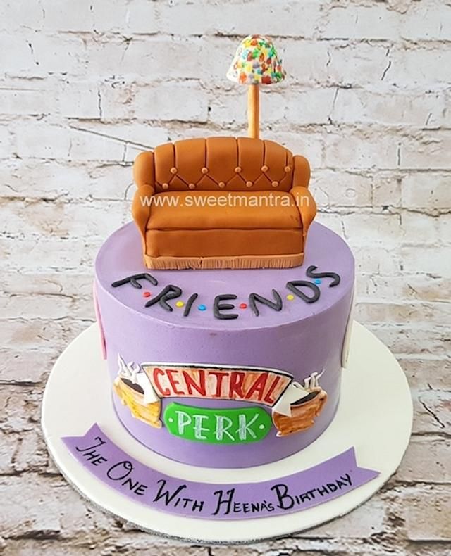 a birthday cake with a couch and candy bar on top, sitting on a plate