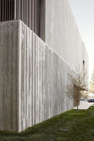 the building is made out of concrete and has vertical slats on it's sides