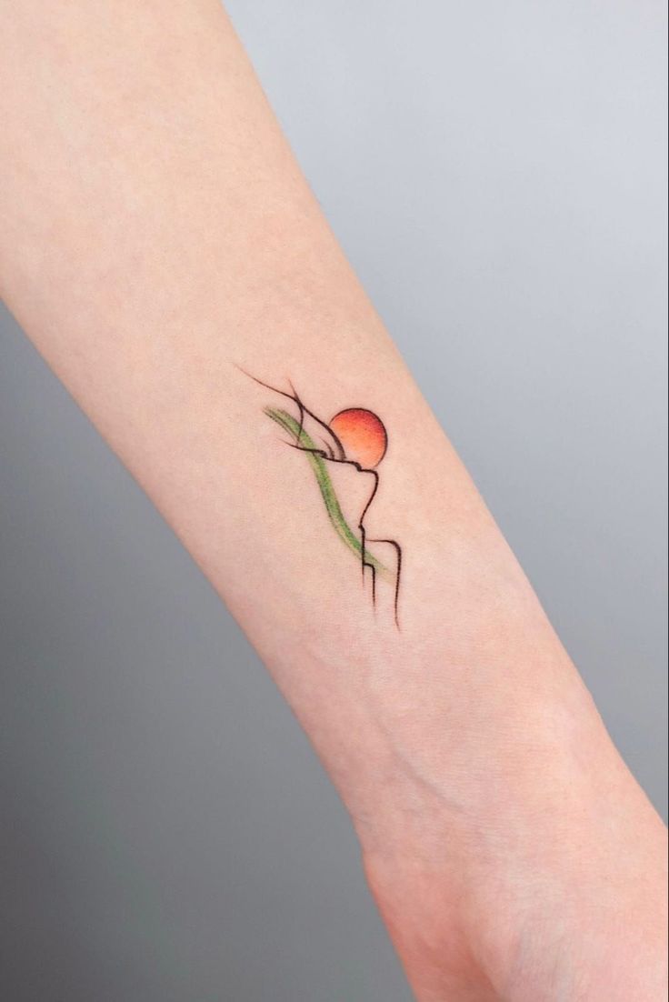 a small tattoo on the arm of a person with an orange and green flower in it