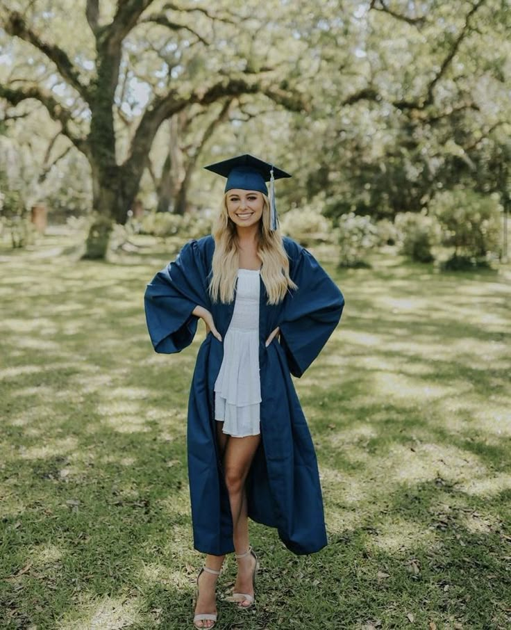 a woman in a graduation cap and gown posing for the camera with her hands on her hips