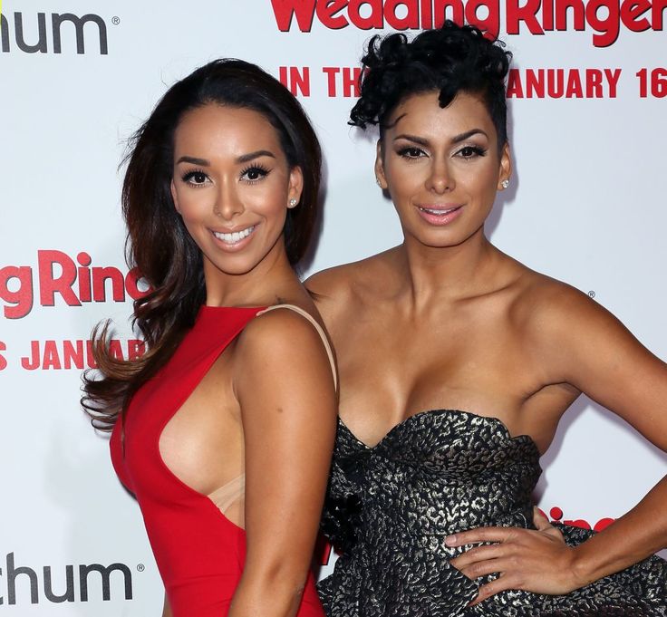 two women standing next to each other on a red carpet