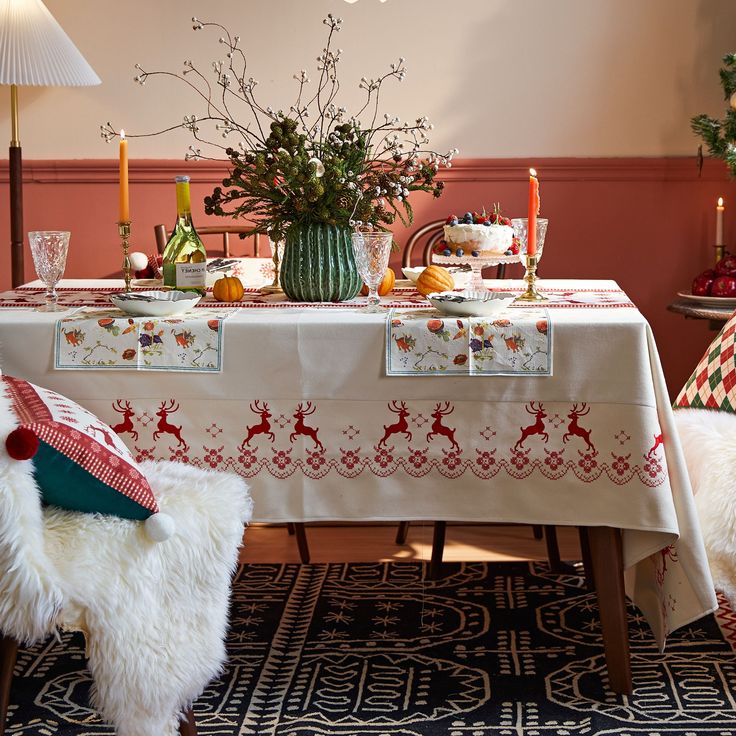 a dining room table with christmas decorations and candles on the top, next to a white chair