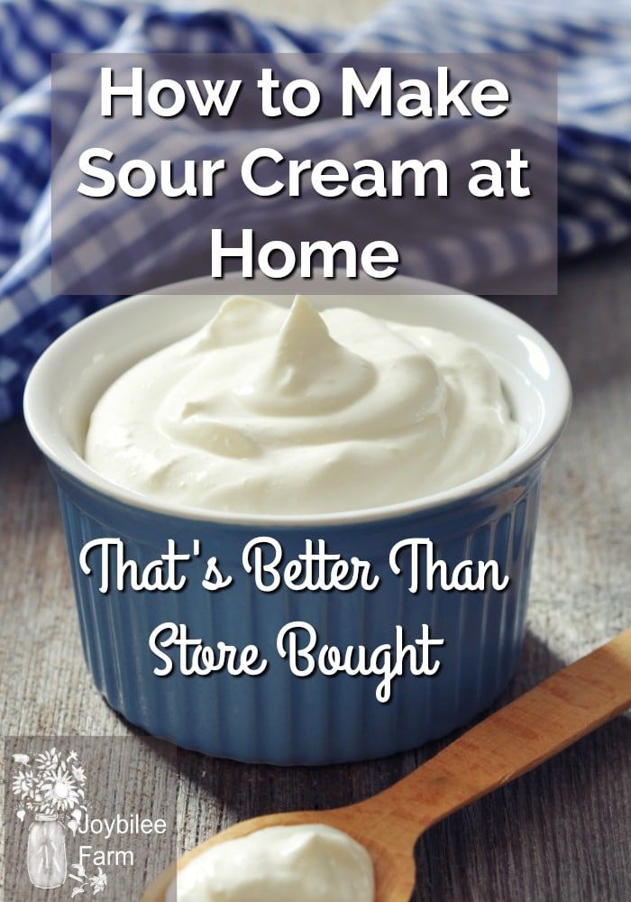 a blue bowl filled with cream next to a wooden spoon on top of a table