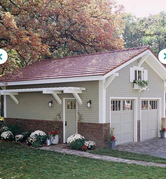 a small gray garage with white trim on the roof and two windows in front of it