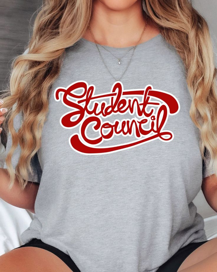 a woman wearing a grey shirt with the words student council printed in red on it